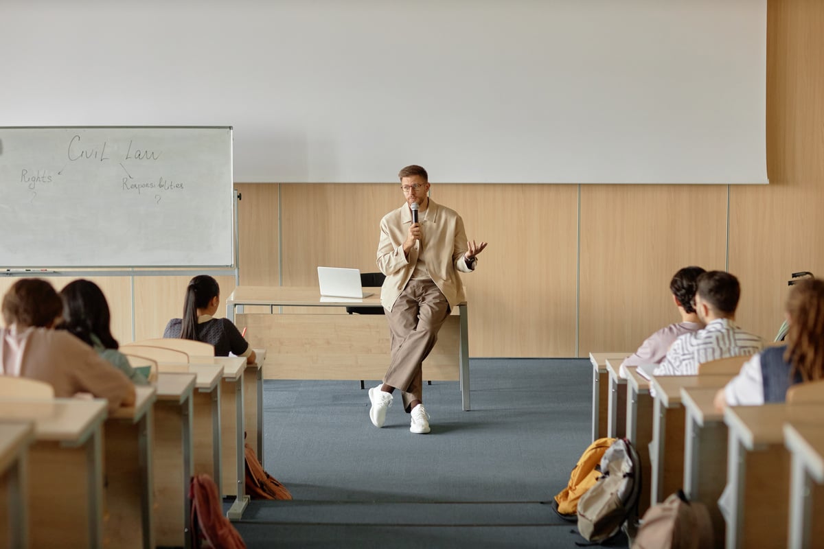 Professor conduzindo uma aula em sala de MBA, promovendo o desenvolvimento de habilidades de liderança.