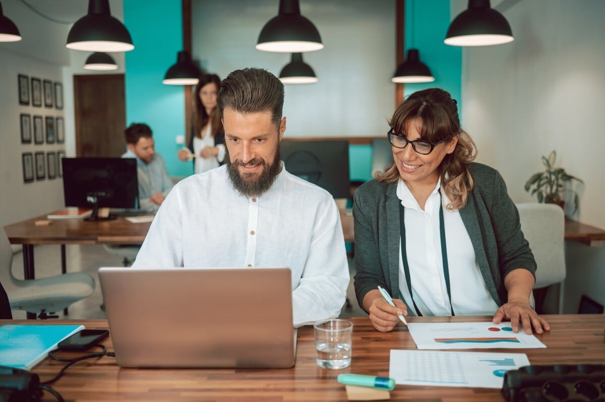 dois executivos comparam programas de MBA e criterios de decisao em computador portatil