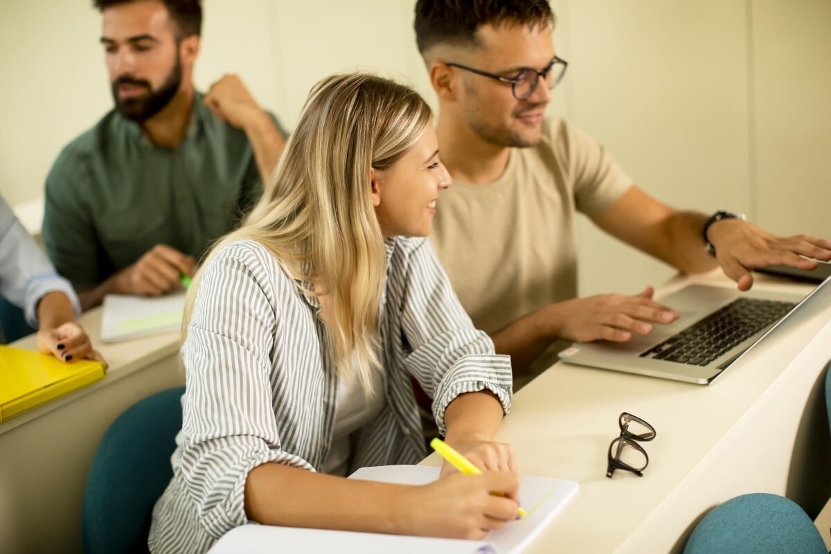 dois profissionais analisam diagnostico de estilo de liderança em computador portatil